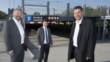 Saarbahn-Geschäftsführer Peter Edlinger präsentiert dem Oberbürgermeister Uwe Conradt und dem Baudezernenten Patrick Berberich das neue Parkdeck auf dem P+R-Platz am Brebacher Bahnhof. Image