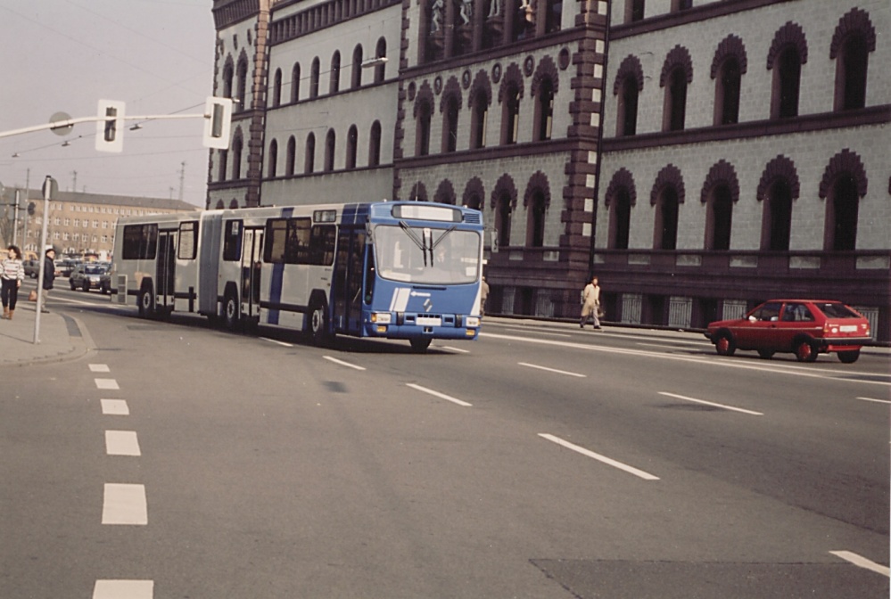 Ein Renault-Gelenkbus des Typs PR 180.2 fährt durch die Trierer Straße der 80er Jahre. Im Hintergrund rechts die Fassade der Bergwerksdirektion (heute Europa-Galerie), dahinter eine große Brachfläche und links im Hintergrund die alte Hauptpost Ein Renault-Gelenkbus des Typs PR 180.2 fährt durch die Trierer Straße der 80er Jahre. Im Hintergrund rechts die Fassade der Bergwerksdirektion (heute Europa-Galerie), dahinter eine große Brachfläche und links im Hintergrund die alte Hauptpost